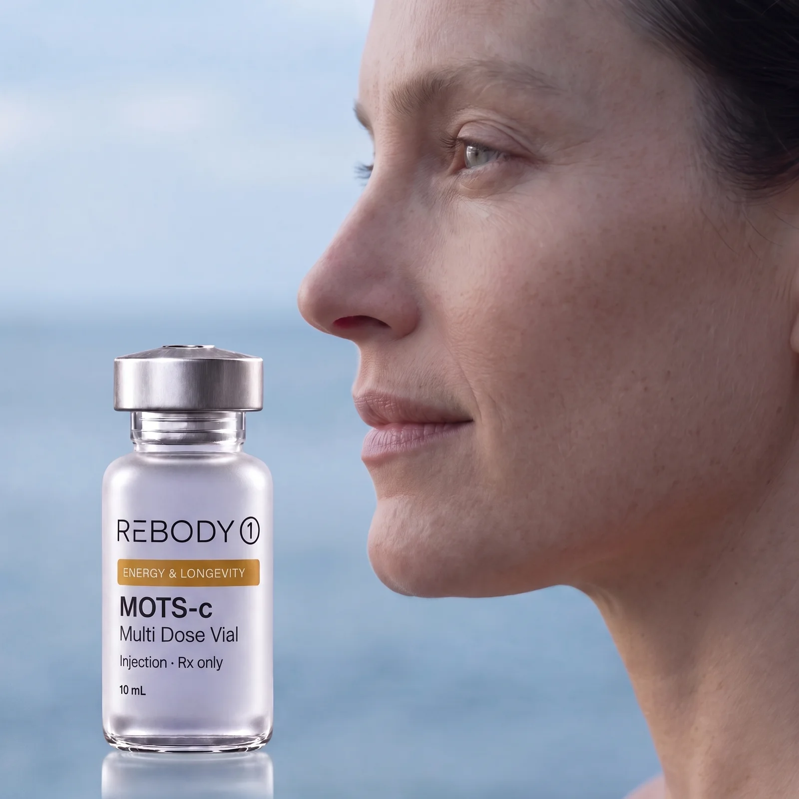 A woman in profile by a misty sea beside a MOTS-c vial